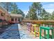 Inviting back deck with colorful stools, cozy seating, and views of the surrounding trees and blue sky at 7516 Mourning Dove Dr, Sanford, NC 27332