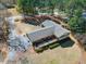 An aerial view showcasing an expansive backyard, wooden deck, patio, and well-manicured landscaping at 7516 Mourning Dove Dr, Sanford, NC 27332