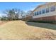Expansive backyard featuring a house with large windows and mature trees under a clear blue sky at 7516 Mourning Dove Dr, Sanford, NC 27332