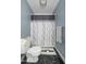 Compact bathroom with a toilet, decorative shower curtain, and grey accents, maximizing a small space at 7516 Mourning Dove Dr, Sanford, NC 27332