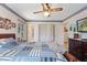 Spacious bedroom with a mix-match quilt, ceiling fan, and multiple closets, providing ample storage and natural light at 7516 Mourning Dove Dr, Sanford, NC 27332