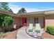 Charming home featuring a beautifully landscaped entrance with a brick facade and vibrant coral front door at 7516 Mourning Dove Dr, Sanford, NC 27332