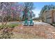 Charming front yard with two Adirondack chairs, flowering tree, and view of the garage at 7516 Mourning Dove Dr, Sanford, NC 27332