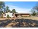 Charming single-story home with a brick facade, manicured lawn, and a bright red front door at 7516 Mourning Dove Dr, Sanford, NC 27332