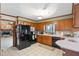 Well-lit kitchen featuring dark appliances, wooden cabinets, and a tiled floor at 7516 Mourning Dove Dr, Sanford, NC 27332
