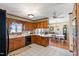 Spacious kitchen with wooden cabinets, tiled floor, and view of a dining area with hardwood flooring at 7516 Mourning Dove Dr, Sanford, NC 27332