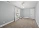 Spacious bedroom with a ceiling fan, neutral carpet, and a window with decorative curtains, creating a peaceful retreat at 8304 Circlewood Ct, Raleigh, NC 27615