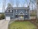 Charming two-story home with blue siding, black shutters, and a bright yellow front door at 8304 Circlewood Ct, Raleigh, NC 27615