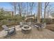 An outdoor firepit is surrounded by chairs and benches, and set on a brick patio at 8304 Circlewood Ct, Raleigh, NC 27615