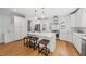 Spacious white kitchen with stainless steel appliances, quartz countertops, and hardwood floors at 8304 Circlewood Ct, Raleigh, NC 27615