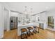 Spacious white kitchen with stainless steel appliances, quartz countertops, and hardwood floors at 8304 Circlewood Ct, Raleigh, NC 27615
