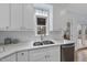 Clean kitchen with white cabinets, granite countertops, stainless steel dishwasher, and large sink at 8304 Circlewood Ct, Raleigh, NC 27615
