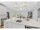 Open-concept kitchen with white cabinets, large island with sink, and view to the dining and living areas at 8304 Circlewood Ct, Raleigh, NC 27615