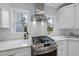 Bright white kitchen with stainless steel stove, white tile backsplash, and lots of natural light at 8304 Circlewood Ct, Raleigh, NC 27615