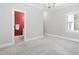 Spacious bedroom with neutral walls, plush carpeting, and a doorway leading to a red-walled bathroom at 100 Dunedin Ct, Cary, NC 27511