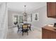 Bright dining area with a modern chandelier, table with seating for four, and access to an outdoor space at 100 Dunedin Ct, Cary, NC 27511