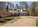 Stately white home with black shutters, mature trees, and a long driveway at 100 Dunedin Ct, Cary, NC 27511