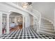 Grand foyer boasts black and white checkered floors, curved staircase and chandelier lighting at 100 Dunedin Ct, Cary, NC 27511