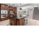 Gourmet kitchen featuring granite countertops, custom wood cabinetry, stainless steel appliances, and a central island at 100 Dunedin Ct, Cary, NC 27511