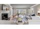 Well-lit living room with fireplace, hardwood floors, comfortable seating, and views of the backyard at 100 Dunedin Ct, Cary, NC 27511