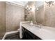Chic powder room with a dark vanity, marble floors, and a decorative mirror at 100 Dunedin Ct, Cary, NC 27511