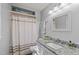 Bathroom featuring modern vanity with granite countertop and shower with neutral curtain at 1004 Plateau Ln, Raleigh, NC 27615