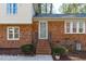 Close-up of a brick front porch with steps leading to a screen door at 1004 Plateau Ln, Raleigh, NC 27615