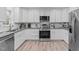 Updated kitchen with stainless steel appliances, white cabinetry, and stone countertops at 1004 Plateau Ln, Raleigh, NC 27615