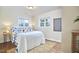 Cozy bedroom with natural light, featuring a white bed with blue accents and hardwood floors with a jute rug at 101 Newell St, Durham, NC 27705