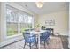 Bright dining room with white table and blue chairs, featuring large windows and a view of the outdoors at 101 Newell St, Durham, NC 27705