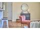 Cozy living room with a stylish chair, a round mirror, and hardwood flooring at 101 Newell St, Durham, NC 27705