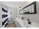 Bathroom with a dual sink vanity, modern fixtures, and a blue and white striped shower curtain at 1012 Mountain Laurel Dr, Raleigh, NC 27603