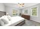 Bright bedroom with white bedding, ceiling fan, dresser, and natural light from two windows at 1012 Mountain Laurel Dr, Raleigh, NC 27603