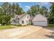 Exterior view of home featuring an attached garage, long driveway, and mature trees at 1012 Mountain Laurel Dr, Raleigh, NC 27603