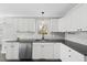 Well-lit kitchen featuring modern cabinets, appliances, a large sink, and a view to the entrance of the house at 1012 Mountain Laurel Dr, Raleigh, NC 27603