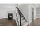 Elegant staircase with carpeted steps, a fireplace, and modern lighting, creating a welcoming ambiance at 1012 Mountain Laurel Dr, Raleigh, NC 27603