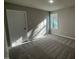 Sun-filled bedroom featuring neutral walls, plush carpeting, and a bright window casting light across the space at 108 Faucette Dr, Selma, NC 27576