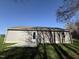 Exterior shot with a grassy lawn and a clear view of the home's structure under a bright blue sky at 108 Faucette Dr, Selma, NC 27576