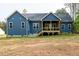 Back exterior of blue home with covered wood deck and large backyard at 110 Purslane Dr, Franklinton, NC 27525