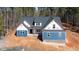 New construction home featuring blue siding, brick accents, and a modern roof design at 110 Purslane Dr, Franklinton, NC 27525