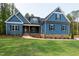 Charming blue home with manicured lawn, brick base, craftsman accents, and inviting covered entryway at 110 Purslane Dr, Franklinton, NC 27525