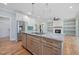 Kitchen island with seating, stainless steel appliances, and hardwood floors at 110 Purslane Dr, Franklinton, NC 27525