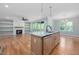 Kitchen island featuring sink, stainless appliances, and fireplace in living room at 110 Purslane Dr, Franklinton, NC 27525