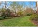 Lush green backyard featuring mature trees and landscaping, offering a private outdoor oasis at 113 Kings Castle Dr, Apex, NC 27502