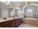 Elegant bathroom features a double vanity, granite counters, and a luxurious tub with tile surround at 113 Kings Castle Dr, Apex, NC 27502