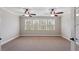 Spacious bedroom featuring two ceiling fans, neutral paint, and an abundance of natural light from the large window at 113 Kings Castle Dr, Apex, NC 27502