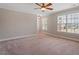 Large bedroom featuring neutral paint, plush carpet, ceiling fan, and an abundance of natural light from the window at 113 Kings Castle Dr, Apex, NC 27502