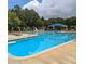 Sparkling community pool with lounge chairs and umbrellas, perfect for summer relaxation at 113 Kings Castle Dr, Apex, NC 27502