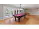 Bright game room with pool table, foosball table, and glass paneled doors to the exterior at 113 Kings Castle Dr, Apex, NC 27502