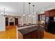 Open kitchen featuring a breakfast bar, granite countertops, and hardwood floors at 113 Kings Castle Dr, Apex, NC 27502